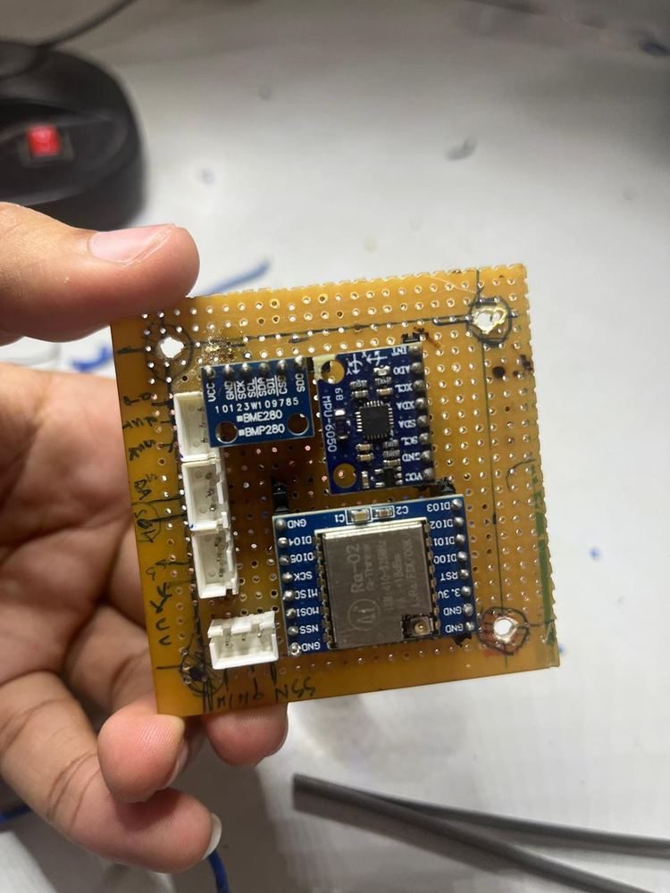 CanSat perf-board PCB top side showing BMP280 barometric sensor, MPU6050 IMU, and Ra-02 LoRa module on hand-cut yellow perf-board